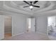 This bedroom features a tray ceiling, fan, carpeted floors and a walk-in closet and an ensuite bathroom at 232 Barrett Springs Way, Canton, GA 30115