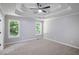 Large bedroom with tray ceilings, fan and two windows offers a bright and comfortable space at 232 Barrett Springs Way, Canton, GA 30115