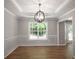 The dining room showcases wood flooring, wainscoting detail and a stylish lighting fixture at 232 Barrett Springs Way, Canton, GA 30115