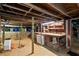 Unfinished basement with exposed beams, storage shelves, and a concrete floor, offering potential at 433 Pine Dr, Pine Lake, GA 30072