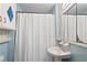 Classic bathroom featuring blue tile, a pedestal sink, and a shower with a white curtain at 433 Pine Dr, Pine Lake, GA 30072