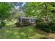 Quaint home with screened porch nestled amidst lush landscaping and mature trees, creating a serene setting at 433 Pine Dr, Pine Lake, GA 30072