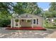 Inviting front porch with a red deck, perfect for relaxing, complemented by hanging plants and natural light at 433 Pine Dr, Pine Lake, GA 30072