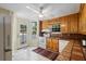 Open kitchen featuring white appliances, tile countertops, wood cabinets, and outdoor views at 433 Pine Dr, Pine Lake, GA 30072