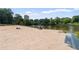 Expansive sandy beach with families enjoying recreational activities alongside a tranquil lake at 433 Pine Dr, Pine Lake, GA 30072