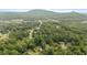 Scenic aerial view of homes surrounded by lush greenery and mountains in the distance at 506 Bluff Ct, Woodstock, GA 30188