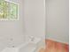 Bright bathroom features a large soaking tub with a view of the trees outside at 506 Bluff Ct, Woodstock, GA 30188