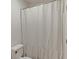 Bathroom featuring a toilet next to a shower with a white ruffled curtain, creating a relaxing atmosphere at 506 Bluff Ct, Woodstock, GA 30188
