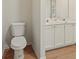 Bathroom featuring a toilet and a double sink vanity with white cabinets at 506 Bluff Ct, Woodstock, GA 30188