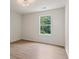 Clean and bright bedroom featuring neutral walls and a large window letting in natural light at 506 Bluff Ct, Woodstock, GA 30188