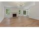 Bright living room with a fireplace, modern lighting, hardwood floors, and large windows with green views at 506 Bluff Ct, Woodstock, GA 30188
