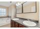 Bathroom featuring a double sink vanity, and a white tub with brown tile at 1001 Dunning Se St, Atlanta, GA 30315