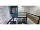 View of a staircase with carpet and modern metal railings, illuminated by a decorative chandelier at 1033 Hawk Creek Trl, Lawrenceville, GA 30043