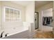 Bright bathroom featuring soaking tub, a large window, and a glass door to the shower at 1076 Scenic Park Trl, Lawrenceville, GA 30046