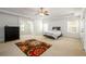 Expansive bedroom featuring a tray ceiling, large windows, neutral carpet, and ceiling fan at 1076 Scenic Park Trl, Lawrenceville, GA 30046