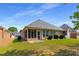 Spacious backyard with lush green lawn, mature trees, screened porch, and fenced perimeter at 115 Pinnacle Ln, Mcdonough, GA 30253