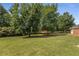 Green grass and mature trees accent the manicured lawn in the property's expansive backyard at 115 Pinnacle Ln, Mcdonough, GA 30253