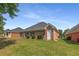 The brick home features a lush green lawn, trimmed shrubs, and a screened porch in its well-maintained backyard at 115 Pinnacle Ln, Mcdonough, GA 30253