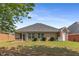 Well-maintained brick home featuring a screened porch, lush green lawn, and neatly trimmed shrubs in the backyard at 115 Pinnacle Ln, Mcdonough, GA 30253
