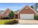 Well-maintained brick home featuring a two-car garage and mature landscaping at 115 Pinnacle Ln, Mcdonough, GA 30253