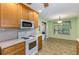 A functional kitchen featuring neutral countertops, white appliances, light wood cabinets, and an adjacent dining area at 115 Pinnacle Ln, Mcdonough, GA 30253