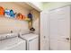 Laundry room with washer, dryer, shelving, and storage providing a dedicated space for efficient laundry tasks at 115 Pinnacle Ln, Mcdonough, GA 30253