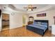 An airy main bedroom featuring wood floors, a tray ceiling, and neutral walls creating a peaceful environment at 115 Pinnacle Ln, Mcdonough, GA 30253