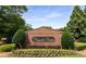 Entrance sign for 'Pinnacle Pointe' with brick surround, manicured shrubs, and vibrant flower beds at 115 Pinnacle Ln, Mcdonough, GA 30253