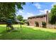 Expansive backyard featuring mature trees, lush lawn, and a playset at 385 Stonebridge Trl, Roswell, GA 30075