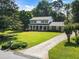 An inviting two-story home with a long driveway, complemented by lush greenery and mature trees at 385 Stonebridge Trl, Roswell, GA 30075