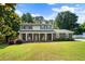 Charming two-story home featuring a covered front porch with rocking chairs and a lush green lawn at 385 Stonebridge Trl, Roswell, GA 30075