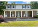 A inviting traditional home featuring a covered porch with seating, flower baskets, and a brick facade at 385 Stonebridge Trl, Roswell, GA 30075