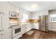 Bright, white kitchen featuring stainless steel appliances, hardwood floors, and ample cabinet space at 385 Stonebridge Trl, Roswell, GA 30075