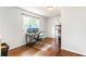 A home office space featuring hardwood floors, a large window, and a computer desk at 385 Stonebridge Trl, Roswell, GA 30075