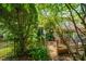 Well-maintained backyard with stone pathway, iron fence, and lush trees at 1344 Fernwood Ne Cir, Brookhaven, GA 30319