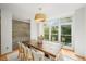 Dining area with a large window, modern lighting fixture, and a view of the landscaped backyard at 1344 Fernwood Ne Cir, Brookhaven, GA 30319