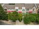 Stylish townhome showcasing red awnings, brick facade, and mature landscaped grounds at 1344 Fernwood Ne Cir, Brookhaven, GA 30319