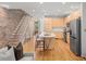 Modern kitchen features stainless appliances, wood flooring, and brick accent wall with staircase at 1344 Fernwood Ne Cir, Brookhaven, GA 30319
