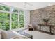 Airy main bedroom with a brick wall, large window and tree views provides a calm and inviting atmosphere at 1344 Fernwood Ne Cir, Brookhaven, GA 30319