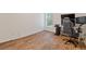 Minimalist bedroom with sleek hardwood floors features a gaming setup with a large monitor and modern chair at 224 Farm Manor Ct, Lawrenceville, GA 30045
