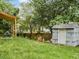Backyard with a partially covered shed and storage, surrounded by a green lawn and mature trees at 3042 Oak Vista Way, Lawrenceville, GA 30044