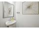 Elegant powder room featuring a pedestal sink, silver framed mirror and modern decor at 20056 Windalier Way, Roswell, GA 30076