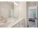 Bathroom featuring dual sinks, a large mirror, and access to an adjoining bedroom at 20056 Windalier Way, Roswell, GA 30076