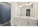 Bathroom featuring dual sinks, a large mirror, and a bathtub with a blue curtain at 20056 Windalier Way, Roswell, GA 30076