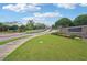Community entrance showcasing the Harlow West signage, beautiful landscaping and a peaceful drive at 20056 Windalier Way, Roswell, GA 30076