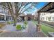Inviting courtyard featuring a covered seating area with green chairs, stone pillars, and manicured landscaping at 20056 Windalier Way, Roswell, GA 30076