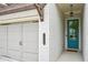 Charming home entrance with a teal-colored door, carriage lighting, and brick wall at 20056 Windalier Way, Roswell, GA 30076