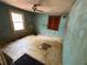 Bedroom with window, peeling light blue walls and damaged floors at 3700 Moore Rd, Austell, GA 30106