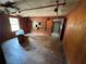 View of living room with wood paneling, damaged floors, and exposed ceiling at 3700 Moore Rd, Austell, GA 30106