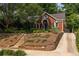 Inviting brick home featuring an American flag, a blue door, and lush landscaping at 608 Hardendorf Ne Ave, Atlanta, GA 30307